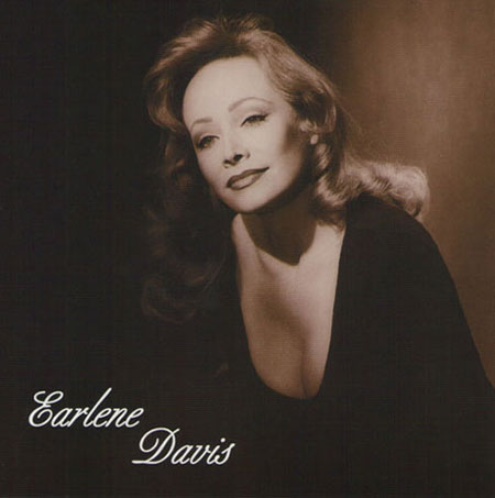 A glamorous black-and-white portrait of Earlene Davis, showcasing her elegant profile and expressive gaze, highlighting her beauty and poise.